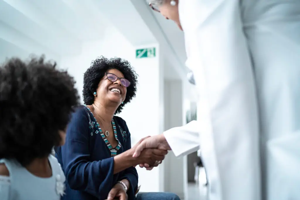 Primary care doctor warmly welcoming new patient at Luckycharm Primary Care clinic in Longview Texas